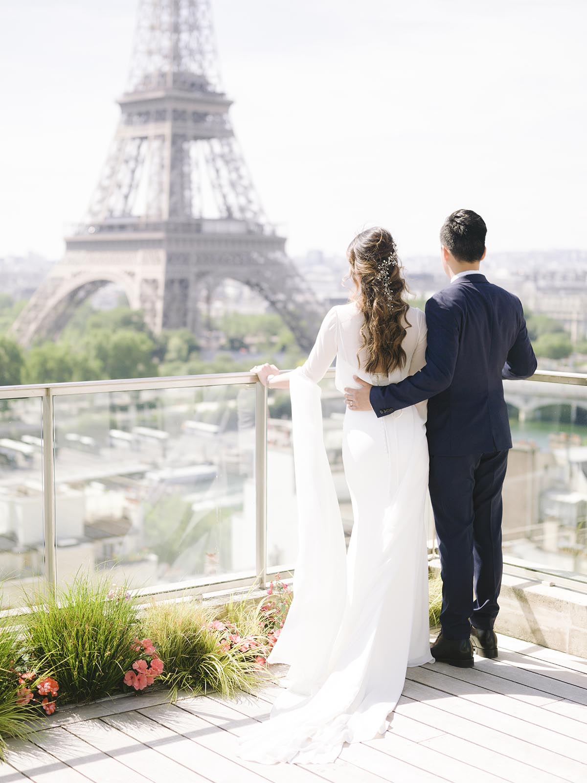 un couple de jeune mariés regardent la tour eiffel sur la terrasse du palace le shangri la à paris